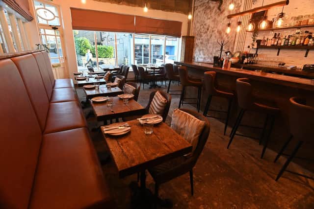 The cosy restaurant has plush leather chairs, stripped-back wooden floors and a tiny open kitchen (Photo: Bruce Rollinson)
