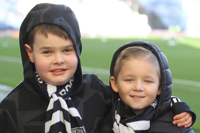 Two young Preston North End supporters get ready to support their team against Bristol City at Deepdale