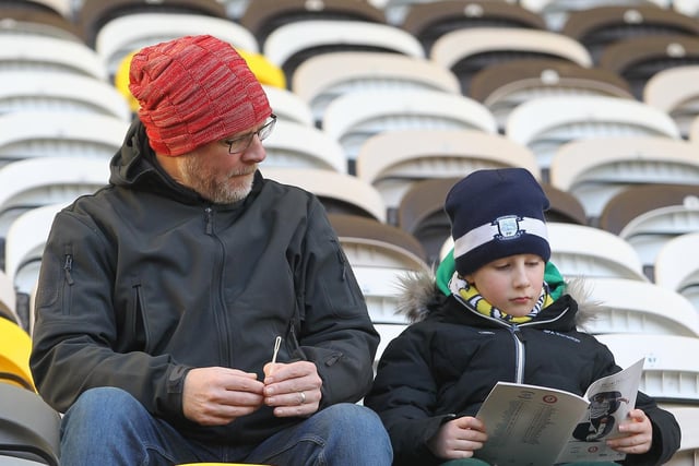 This youngster reads the matchday programme