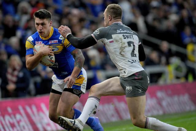 Tom Briscoe is challenged by Hull's Adam Swift during Rhinos' win on Sunday. Picture by Steve Riding.