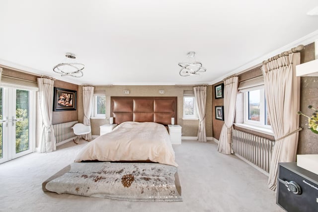 Double doors lead out to the gardens from this exceptional bedroom within the property.