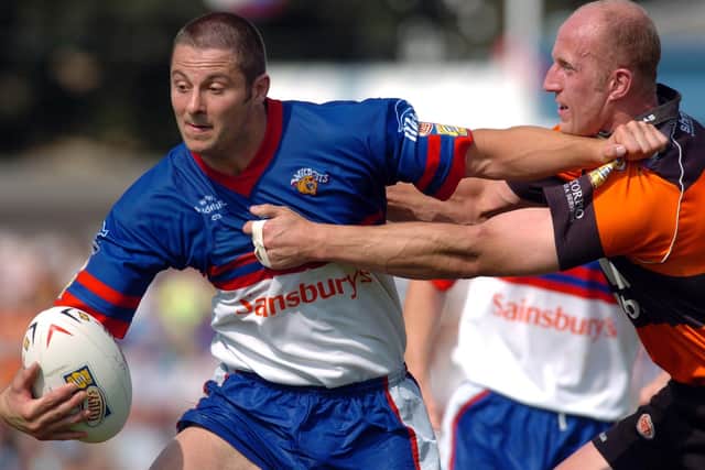 Wakefield's Jamie Field, left, is tackled by Castleford's Darren Rogers during a derby in 2004. Picture by Tony Johnson.