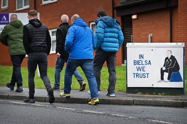 Leeds United supporters walk past a tribute to Marcelo Bielsa, painted by Andy McVeigh, on their way to Elland Road. Pic: Paul Ellis.