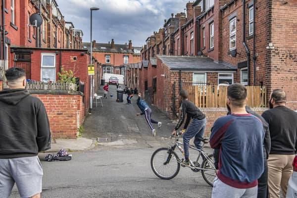 Young adults and children play street cricket in a back street off Hovingham Avenue, Harehills. Picture: Tony Johnson