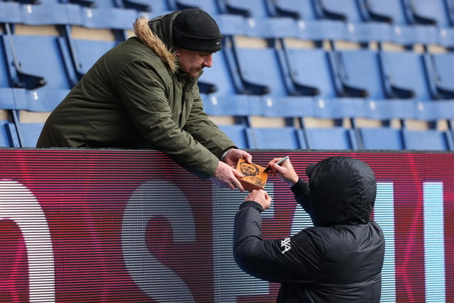 Jurgen Klopp, Manager of Liverpool signs an autograph prior to the Premier League match between Burnley and Liverpool at Turf Moor on February 13, 2022 in Burnley, England.