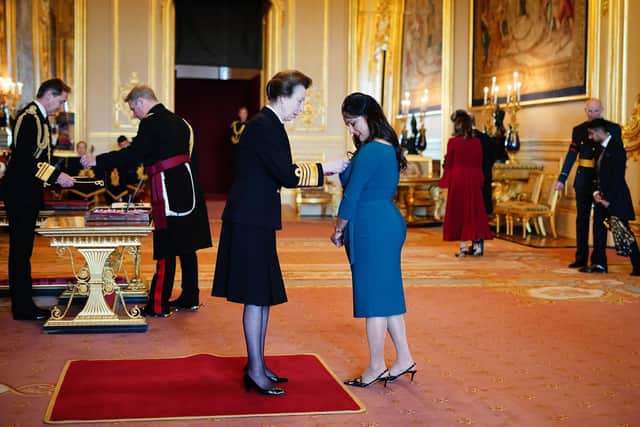 Khairun Nisa receiving her MBE from Princess Anne.