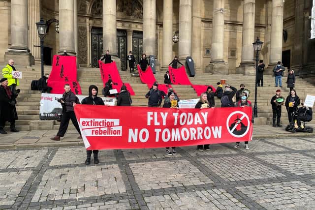 Protestors on the steps of Leeds Town Hall unfurling banners against expansion plans