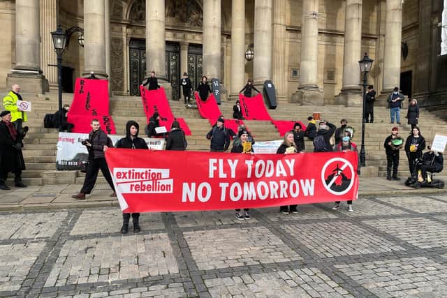 Protestors on the steps of Leeds Town Hall unfurling banners against expansion plans
