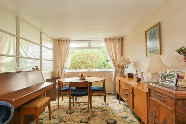 Towards the rear of the property is the dining room. As well as the dining table, the current owner decorated this room with a fabulous 70s-style sideboard and a piano.