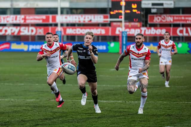 BEAT YOU! Wakefoield Trinity's Harry Bowes and Catalans Dragons' Sam Tomkins race for the ball. Picture by Laurent Selles/Catalans Dragons/SWpix.com