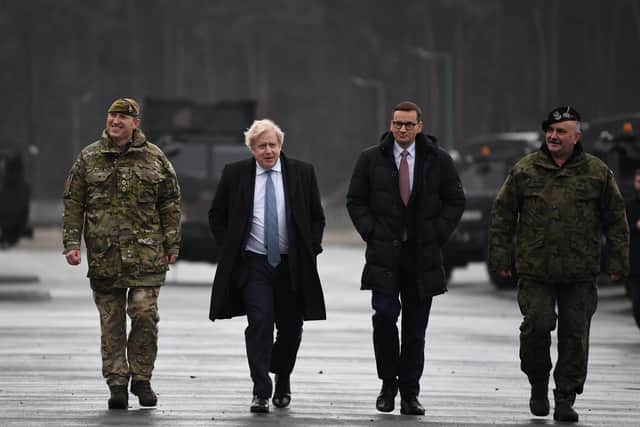 Commander of the UK contribution to the NATO enhanced Forward Presence mission in Estonia and Poland, Colonel Dai Bevan, Prime Minister Boris Johnson, Polish Prime Minister Mateusz Morawiecki, and Polish base commander during a visit to Warszawska Brygada Pancerna military base near Warsaw, Poland, as tensions remain high over the build-up of Russian forces near the border with Ukraine. Photo: Daniel Leal/PA