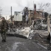 Ukrainian servicemen walk by fragments of a downed aircraft, in Kyiv, Ukraine on Friday. (AP Photo/Oleksandr Ratushniak, File)