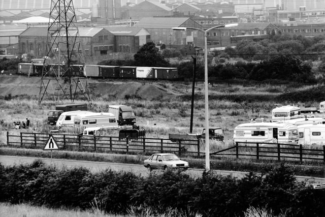 Caravans and trailers from the gypsy and traveller community parked up at Stourton in August 1991. The roadside site is located near railway wagons containing chemicals.