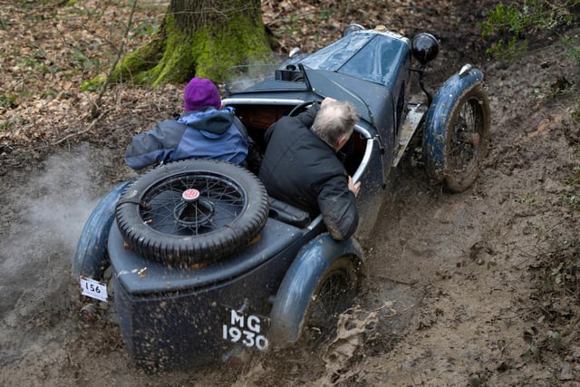 Derek Chatto is all hands to the classic car pump as he peers over the side of his 1929/30 MG M Type up to its hubs in gunk along the John Harris Trial. Photo Rod Kirkpatrick/F Stop Press