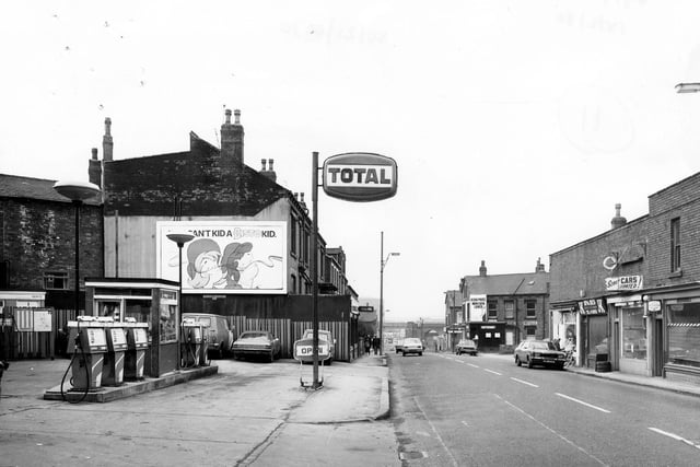 Domestic Street towards the railway viaduct in the distance. On the left is the forecourt of a petrol filling station. The next building along, William Hill bookmakers.
