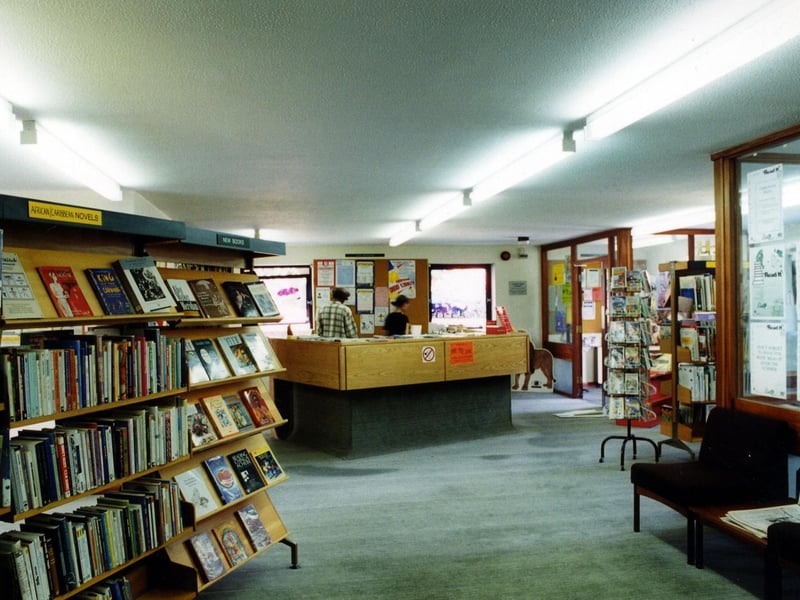 Inside Chapeltown Branch Library on Reginald Terrace. Shelves of African/Caribbean books are on the left. The counter is in the middle and entrance to the right.