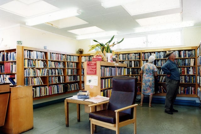 Inside Scholes Branch Library on Station Road. Customers are browsing the fiction shelves around the walls.