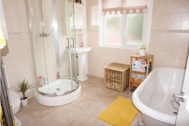 The large bathroom is a family-sized room and includes a roll top bath.