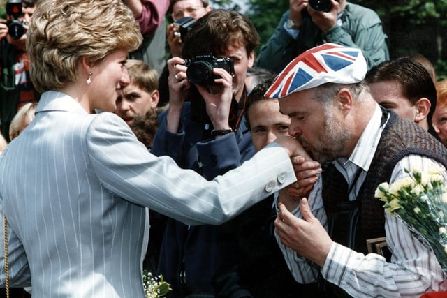 A well wisher kisses the hand of Diana, Princess of Wales.