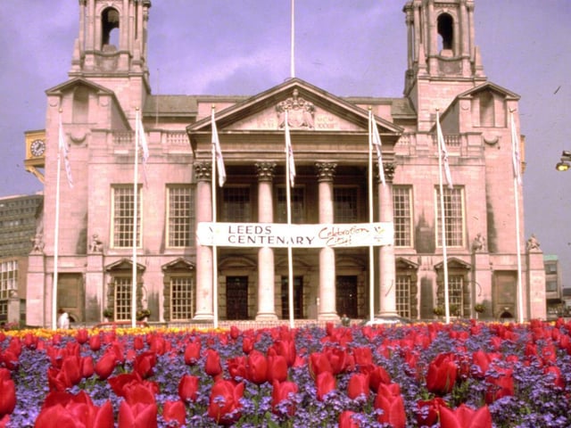 Civic Hall from Nelson Mandela Gardens. A large sign dominates the front of the Civic Hall and promotes 'Leeds Centenary'. One hundred years before on the 13th February 1893 Leeds became a City by Royal Charter of Queen Victoria.