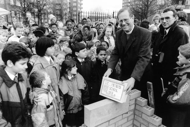 The Bishop of Ripon, the Right Reverend David Young, is surrounded by children as he lays a foundation stone at the new St. Peter's C of E School in Burmantofts in January 1993.