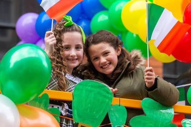 St Patrick's Day Leeds 2022. Pictured Phoebe Smith, and Charlotte Allan, both aged 8, on the shared float of Christ The King Primary School, Bramley, and St Paul's Catholic Primary School, Alwoodley, Leeds.
