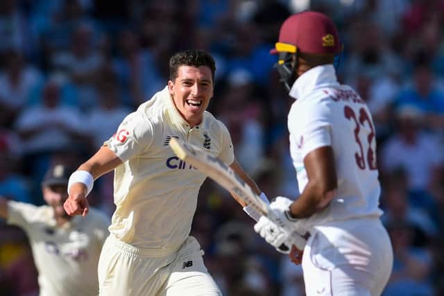 England's Matt Fisher celebrates his first test wicket, the dismissal of West Indies' John Campbell.  (Photo by RANDY BROOKS/AFP via Getty Images)