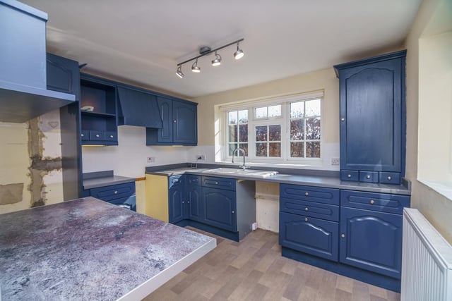 The kitchen space is painted a striking navy blue.