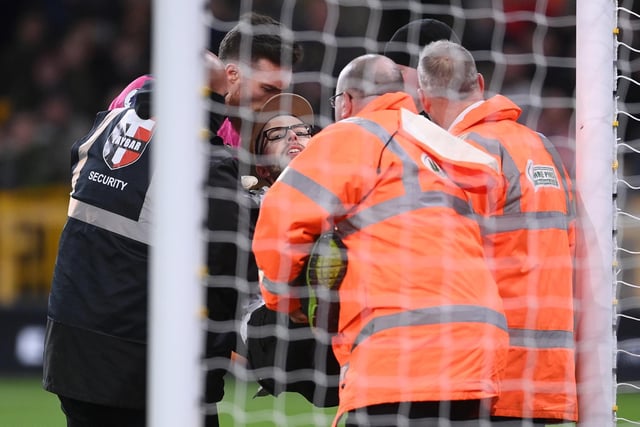 A pitch invader is taken away by stewards.