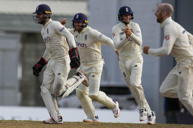 From left, England players Chris Woakes, Jonny Bairstow and captain Joe Root celebrate the dismissal of West Indies' Jason Holder during day five of their second cricket Test match at the Kensington Oval in Bridgetown, Barbados, Sunday, March 20, 2022. (AP Photo/Ricardo Mazalan)