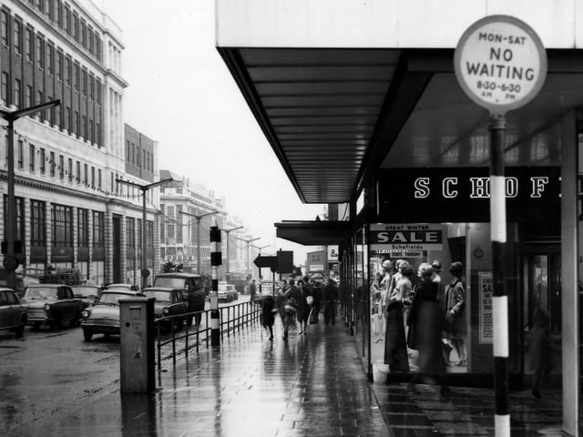 The Headrow from the junction with King Charles Street. Schofields department store is on the site of Victoria Arcade and the former Schofields store, part of which dated back to 1901 when Snowden Schofield first opened a draper's shop here. In 1987 the site was redeveloped into the Schofields Shopping Centre now known as The Headrow Shopping Centre. Lewis's department store is on the left, with the Odeon Cinema further along.