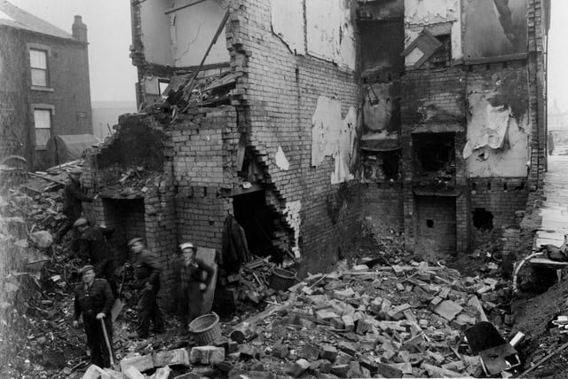 This view shows devastation after an air raid which hit houses on Ingram View in Holbeck in March 1941. A group of workers with spades and baskets are in what would have been the cellar area.