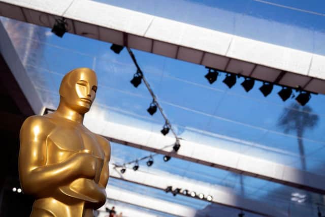 An Oscar statue is seen along the red carpet outside the Dolby Theater in Los Angeles, California, on March 26, 2022, one day before the 94th Academy Awards.