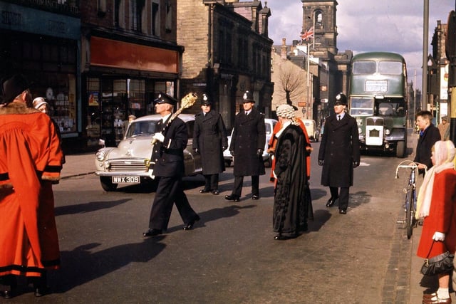 The civic procession travels down Queen Street from the Town Hall to the Wesleyan Church. The mace-bearer can be seen clearly: the Mayor, Mrs. Anne Clayton, in red, is hidden behind the Town Clerk, E. V. Finnigan.