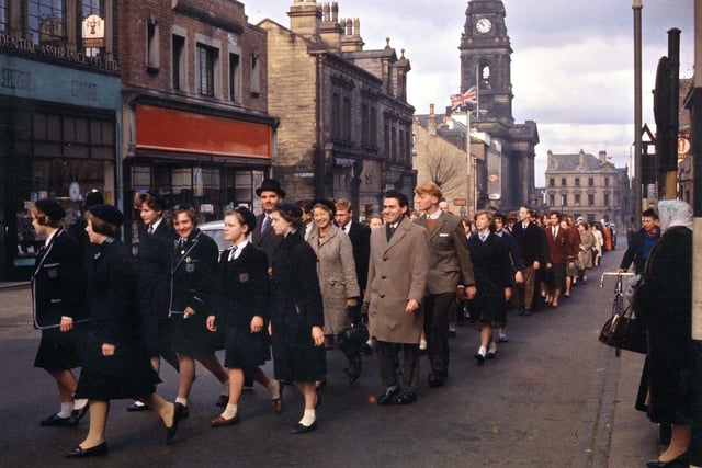 School contingents are seen here in the procession. The girls on the left are from Morley Grammar School, one of them being the daughter of the Vicar of Morley, Rosemary John. Behind them is a contingent from Woodkirk Secondary School led by three members of staff - Mr. F.E. Horsnail, Miss Jane Oddy and Mr. T. Jones; beyond this group there is the group from Victoria Secondary School - the new school at Bruntcliffe at this time was in the process of being built.