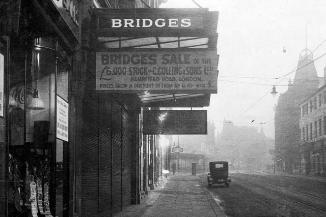This photo shows part of Marks and Spencer Ltd in February 1930, who were listed at 76 Briggate. Thenis Bridges, drapers with sign: 'Bridges sale of the £6,000 stock of C.Coleing and sons Ltd, Hampstead Road. Prices show a discount of from 6/8 to 10/- in the £' in the distance a sign for Warwickshire furnishing Co Ltd is visible.