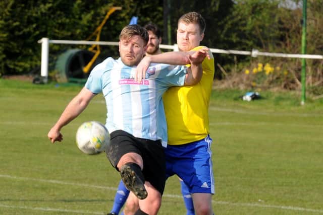 Carlton Athletic's Kieran Corley holds off Charlie Lumley, of  Horsforth St Margarets. Picture: Steve Riding.