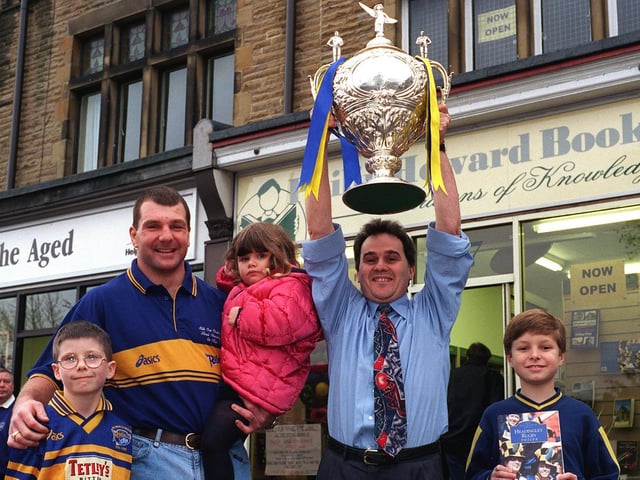 Author of Headingley Rugby Voices Phil Caplan holds aloft the Silk Cut Challenge Cup at the opening of Philip Howard Books on Street Lane in October 1999. He is watched by Leeds Rhinos forward Marc Glanville who opened the shop and some local children Oliver Munden (left) Christopher Collins and sister Rebecca.