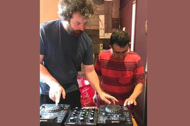 Leeds DJ James Heselwood, founder of the Party People Project, pictured with a past participant, Israr Abbas,  doing some DJing practice.