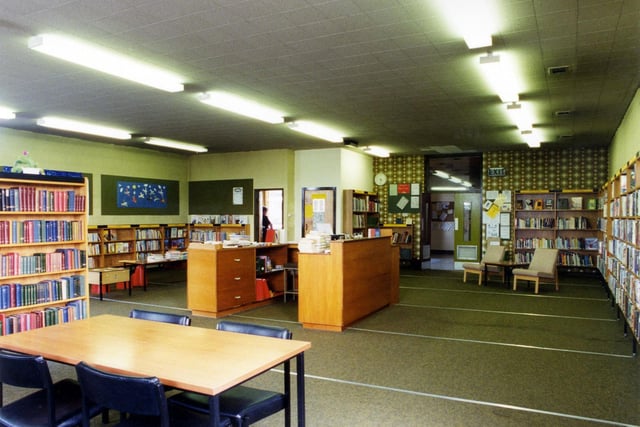 Inside Drighlington Branch Library located on Moorland Road. The counter is in the middle of the room with bookshelves around the walls.