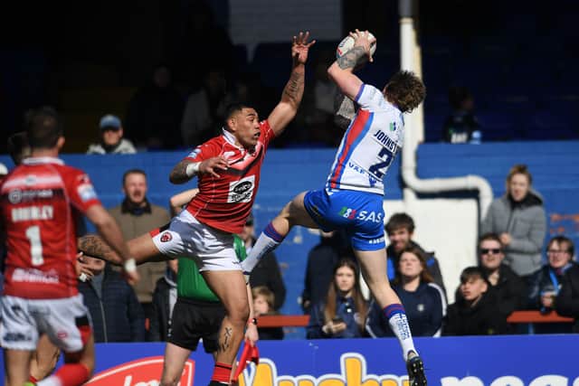 Super leap:
Wakefield's Tom Johnstone catches the ball to score his first try.
Picture: Jonathan Gawthorpe