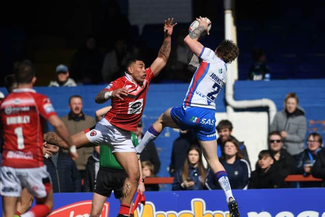 Super leap: 
Wakefield's Tom Johnstone catches the ball to score his first try.
Picture: Jonathan Gawthorpe