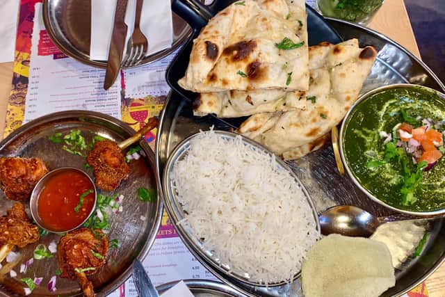 The palak paneer main and chicken lollypop small plate with a portion of garlic naan and rice