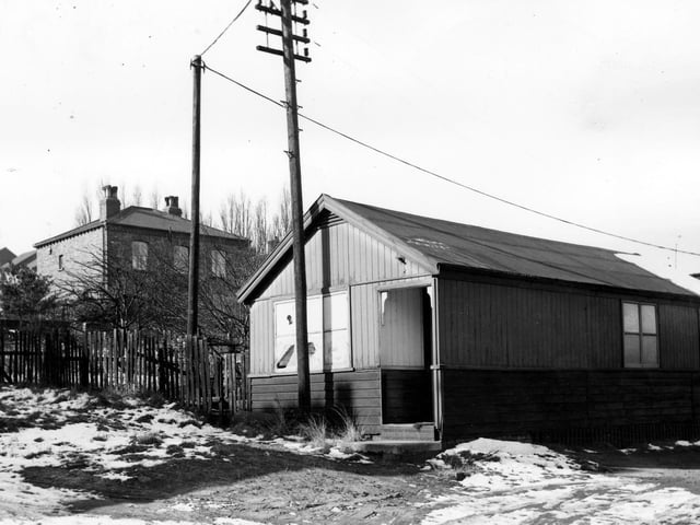 This wooden building on Wesley Street pictured in March 1965 had until recently been the surgery of Dr  Ambrose Bateman. Club Lane can be seen through the trees