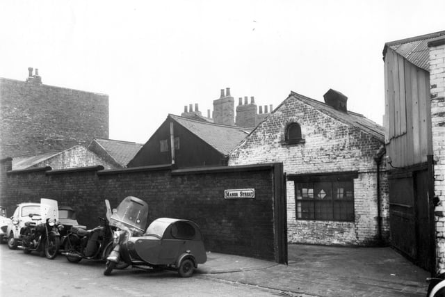 Garages and warehouses on Manor Street pictured in February 1961. Several motorbikes with sidecars are parked towards the left.