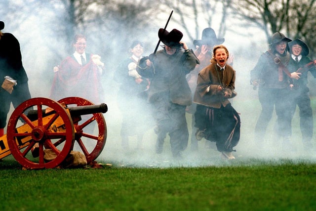 History in the making. Pupils from Allerton High School charge through the cannon smoke into battle during a civil war day staged by the English Civil War Society in November 1997.