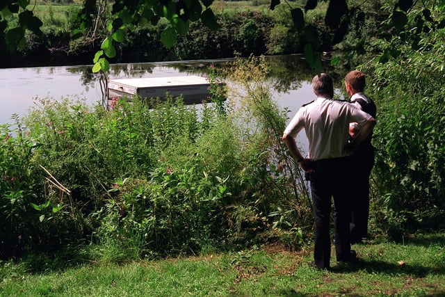Two police officers looks at the trailer belonging to the Royal Shakespeare Company which has been dumped into the river near the weir at Kirkstall Abbey in July 1997. The RSC were performing plays at the Abbey at the time.
