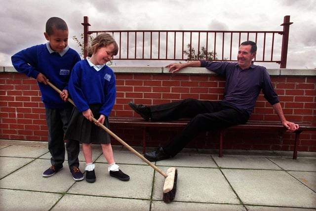 Retiring caretaker Ken Lister watches two of the pupils at Kirkstall Valley Primary School -  Steven Bradshaw and Helen Carr - as they get to work with his brush in September 1998.