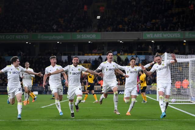 Sam Greenwood celebrates with his Leeds United teammates after Luke Ayling scored the Whites' third goal against Wolves at Molineux. Pic: Laurence Griffiths.