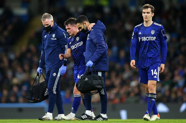 Jamie Shackleton limps off during Leeds United's 7-0 Premier League defeat to Manchester City. Pic: Alex Livesey.